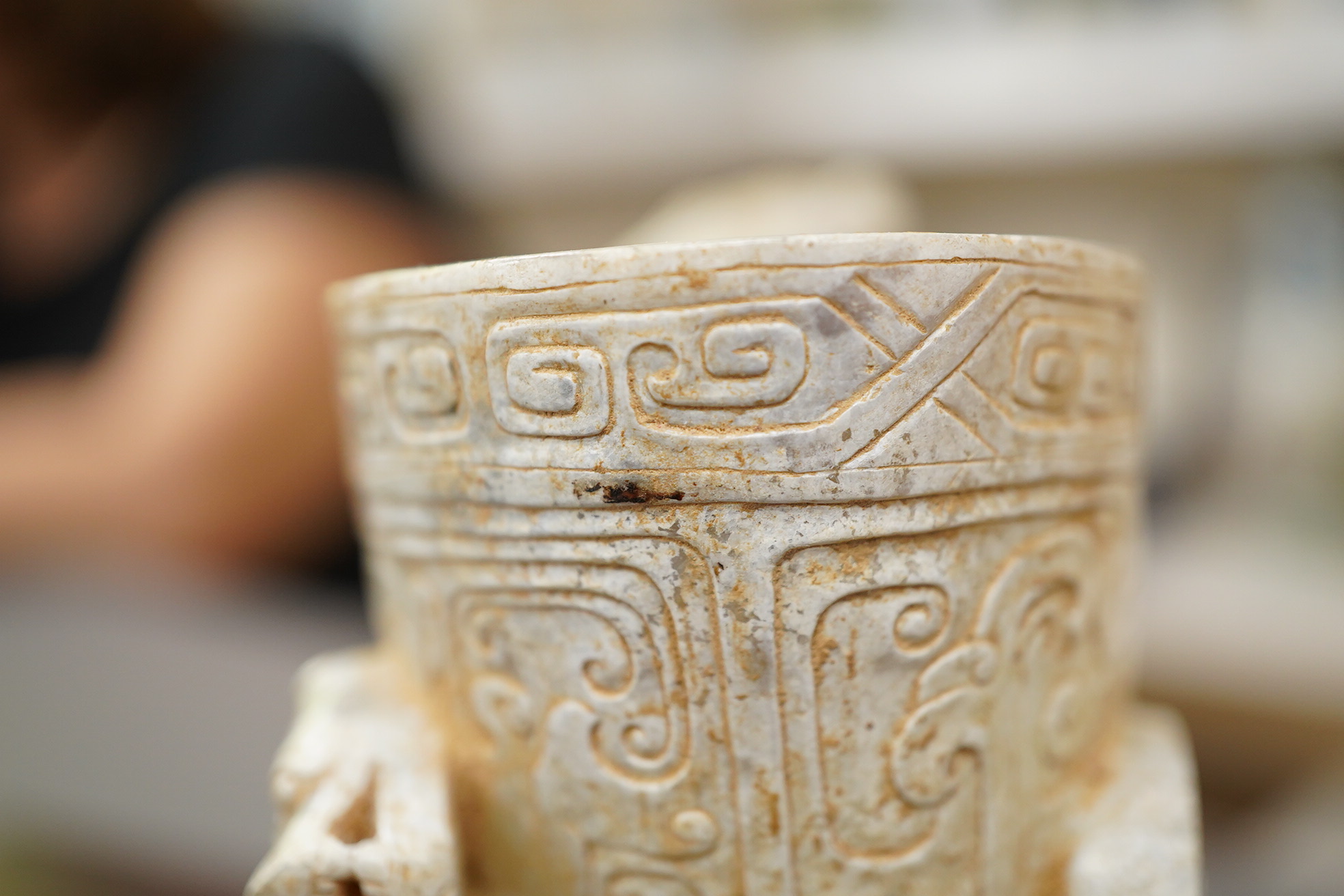 A large Chinese archaistic pale celadon and calcified jade rhyton